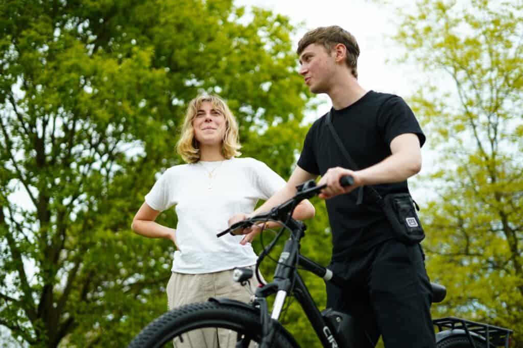 one man and one lady is speaking to each other while the man is holding cirgo cruise electric bike