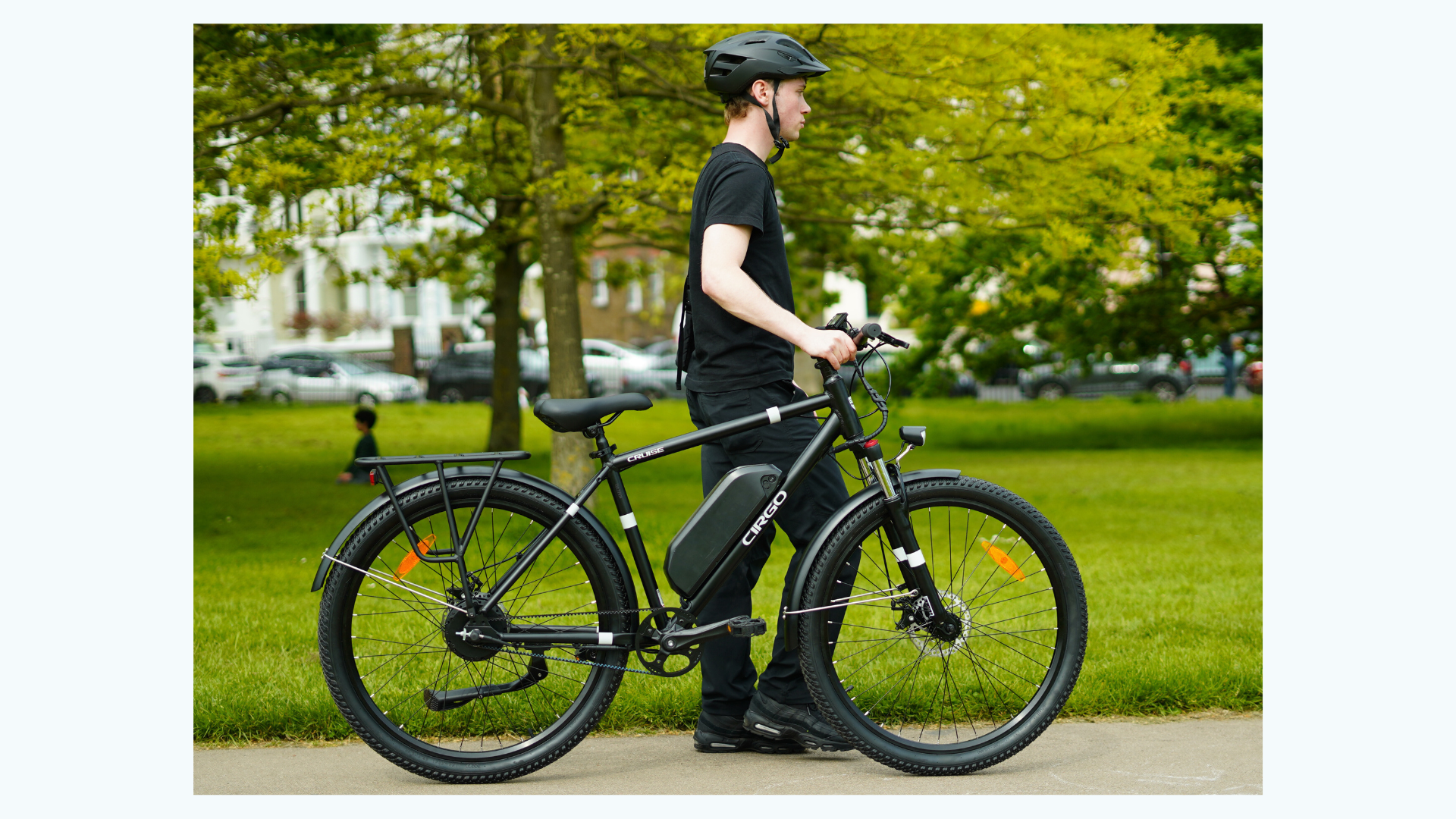 A man with a helmet on is taking Cirgo cruise adult electric bike in the park.
